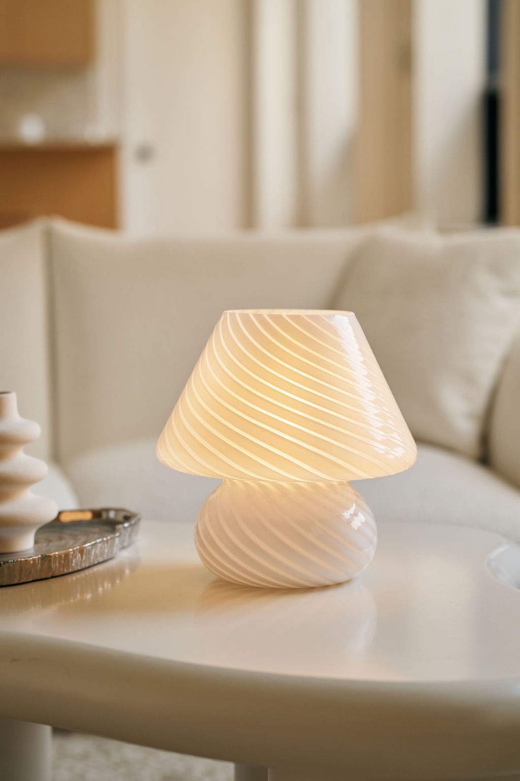 White textured table lamp on a surface with a blurred background