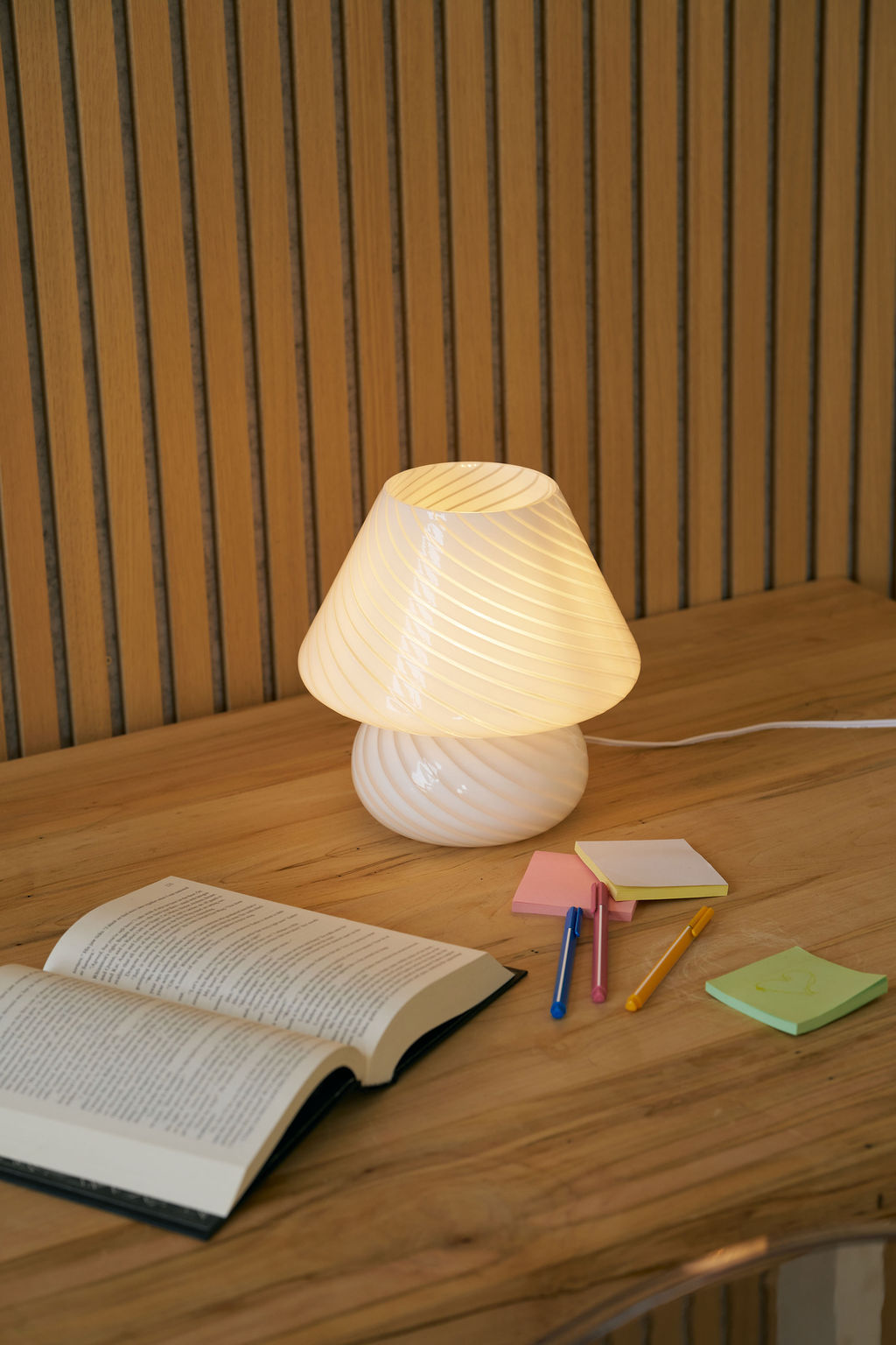Lamp on a wooden table with books and stationery items